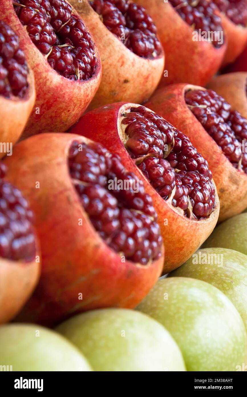 Aperto melograni mele arance al mercato di strada. Frutta contro succo fresco. Foto Stock