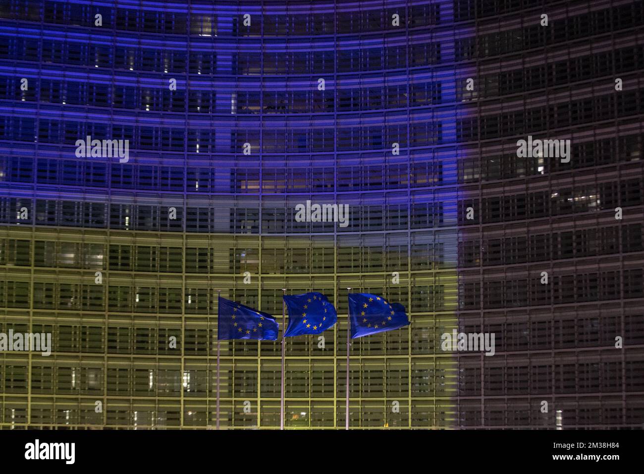 L'immagine mostra le bandiere europee che volano davanti all'edificio Berlaymont, che ospita la sede della Commissione europea, illuminata dai colori della bandiera Ucraina, per mostrare sostegno al popolo ucraino, a Bruxelles, giovedì 24 febbraio 2022. Ieri sera, la Russia ha deciso di invadere diverse regioni ucraine. FOTO DI BELGA NICOLAS MAETERLINCK Foto Stock