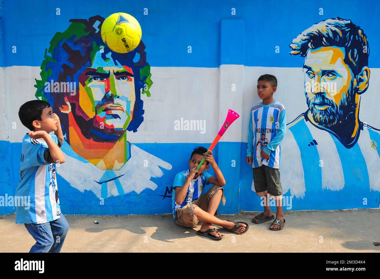 14 dicembre 2022 a Sylhet, Bangladesh: Giovani appassionati argentini che festeggiano, si pone di fronte a un murale del suo eroe, Lionel messi, vince la Croazia nella semifinale di ieri sera e si qualificano per la finale di Coppa del mondo 2022. Il Bangladesh, un paese che non è mai stato qualificato per una coppa del mondo di calcio; ma ha un grande amore per il calcio e ha tifosi seguaci enormi sia per l'Argentina che per il Brasile. Il 14 dicembre 2022 a Sylhet, Bangladesh (Credit Image: © MD Rafayat Haque Khan/eyepix via ZUMA Press Wire) Foto Stock