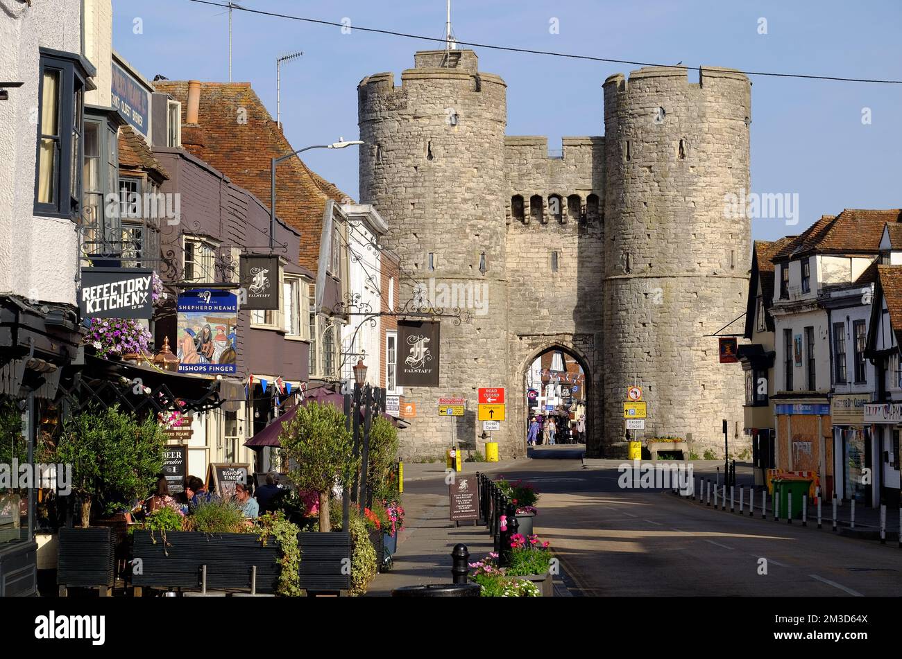 Westgate Towers, una casa medievale poco prima del tramonto e ristoranti, pub e negozi in St Dunstans Street, Canterbury, Kent, Inghilterra Foto Stock
