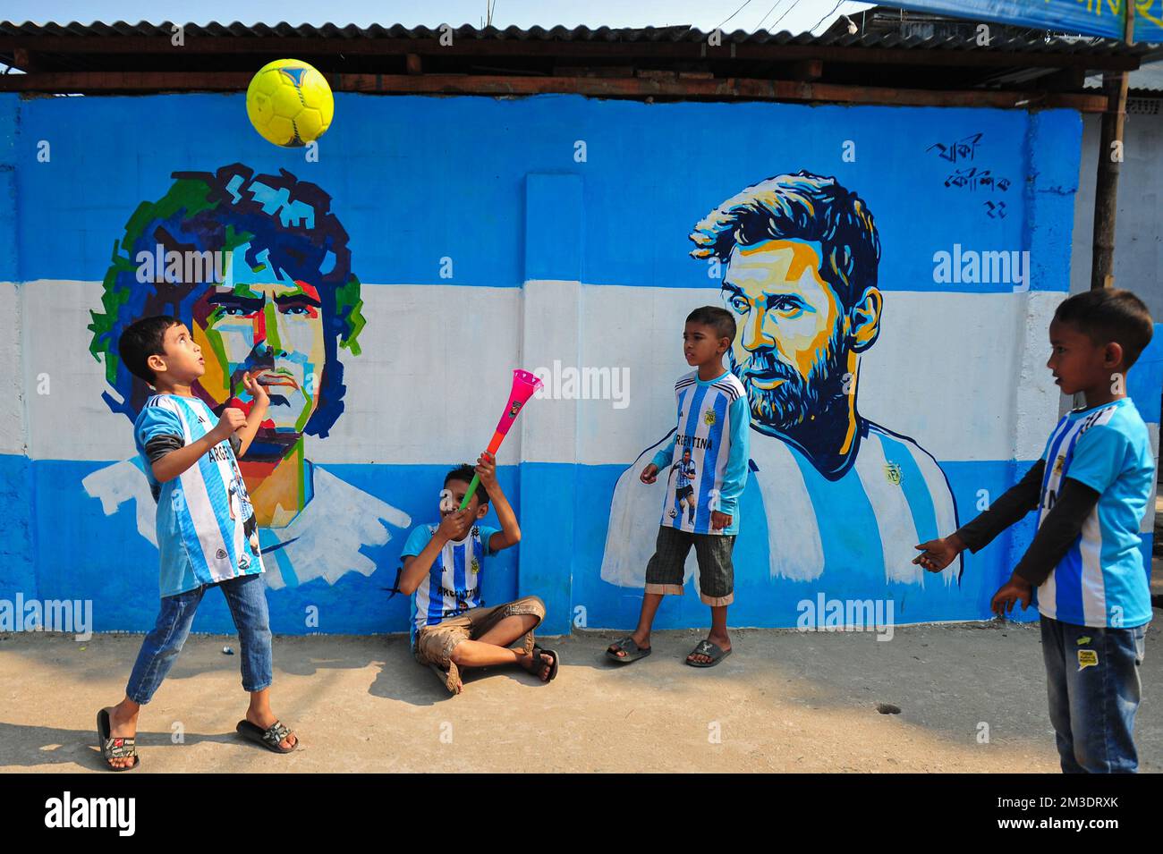 Non esclusiva: 14 dicembre 2022 a Sylhet, Bangladesh: Giovani tifosi argentini che festeggiano, posa davanti a un murale del suo eroe, Lionel messi, vince Cro Foto Stock