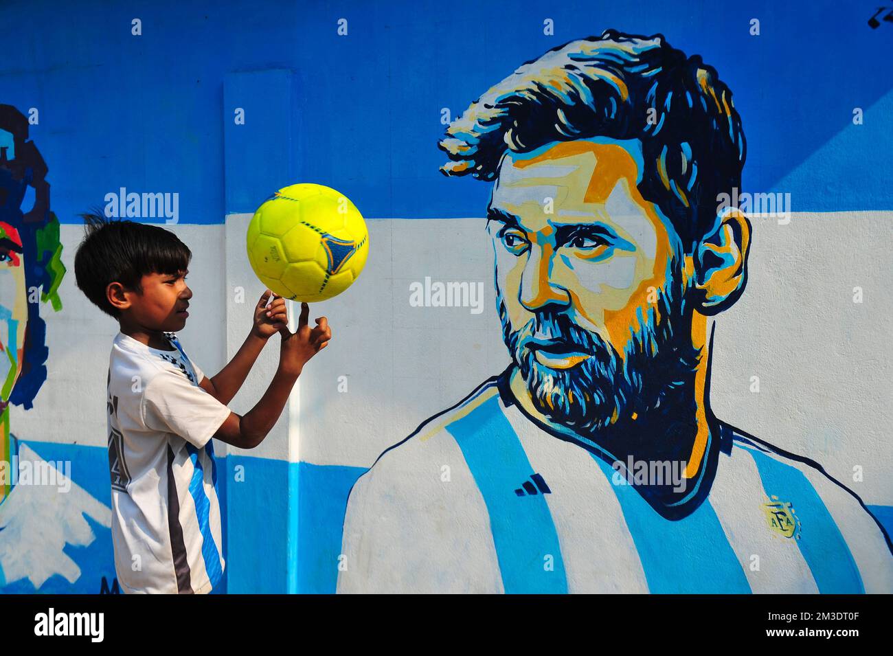 Non esclusiva: 14 dicembre 2022 a Sylhet, Bangladesh: Giovani tifosi argentini che festeggiano, posa davanti a un murale del suo eroe, Lionel messi, vince Cro Foto Stock