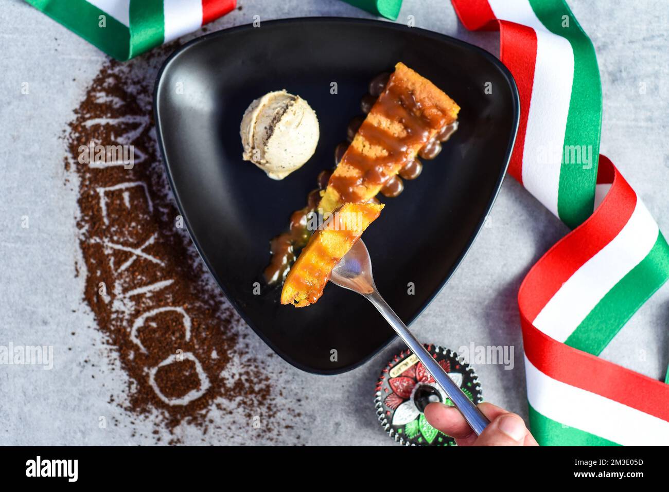 Torta Tlatelolco o torta di mais con gelato al caffè su piatto nero con bandiera messicana Foto Stock