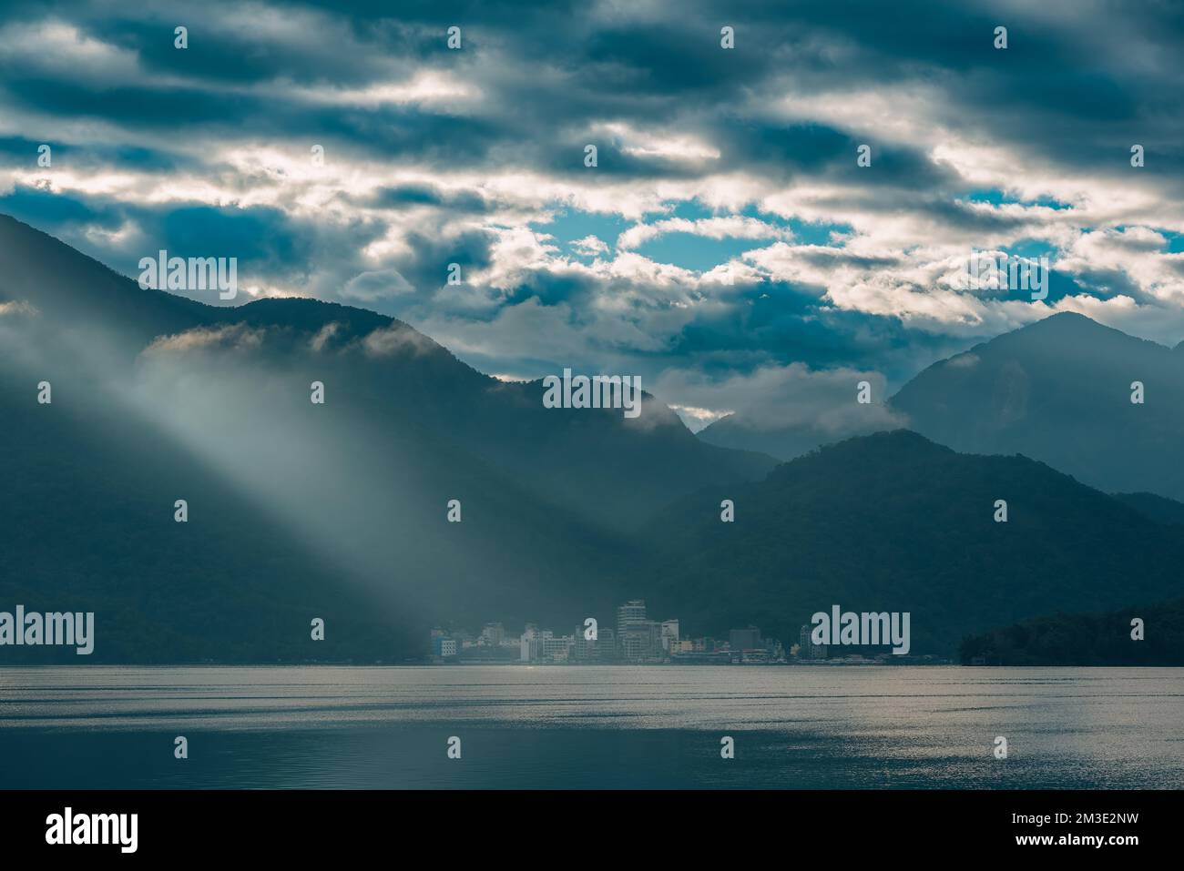 Montagne circondate da nuvole. Il raggio crepuscolare brilla sul villaggio. Molo di Chaowu, area panoramica nazionale del lago Sun Moon. Contea di Nantou, Taiwan Foto Stock