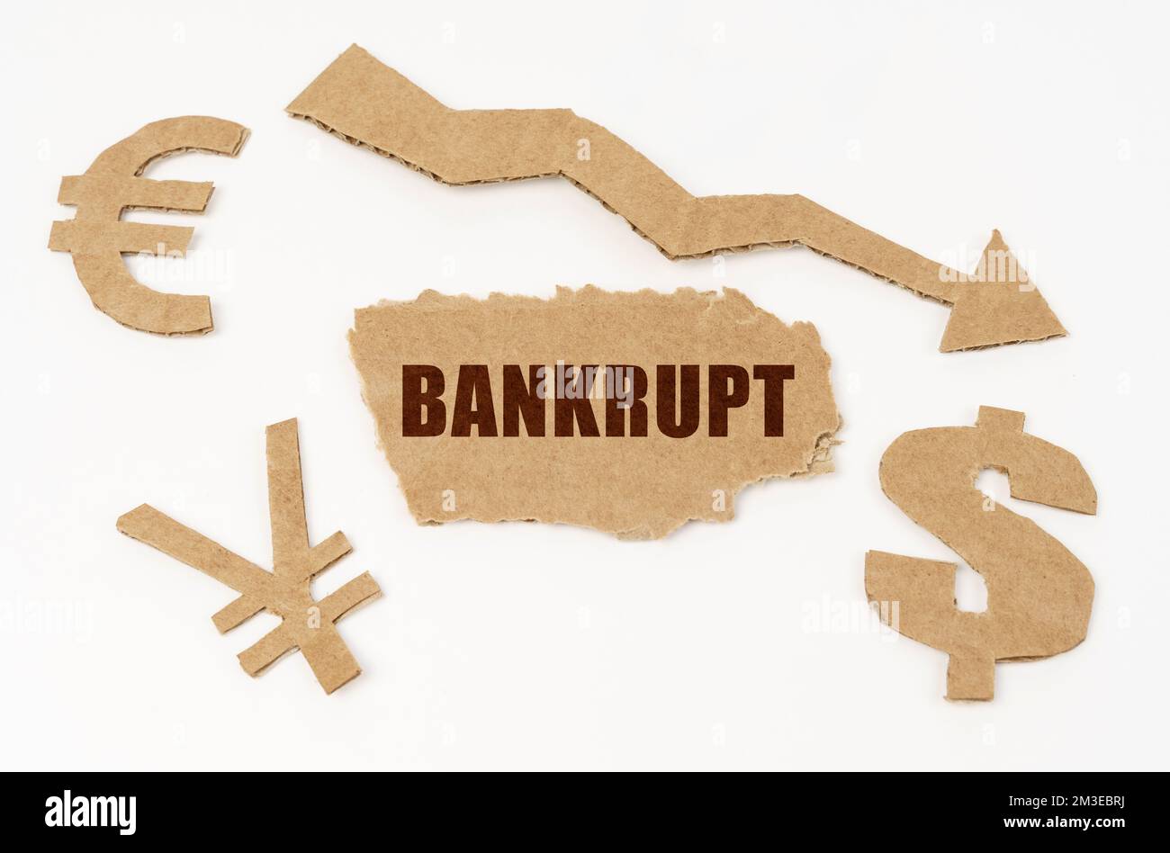 Concetto di economia e crisi. Su sfondo bianco, simboli di dollaro, euro e yen, una freccia rivolta verso il basso e un cartone con l'iscrizione - Bankrup Foto Stock