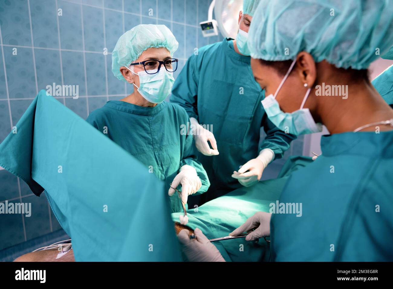 Il team di chirurgia operanti in una sala chirurgica Foto Stock