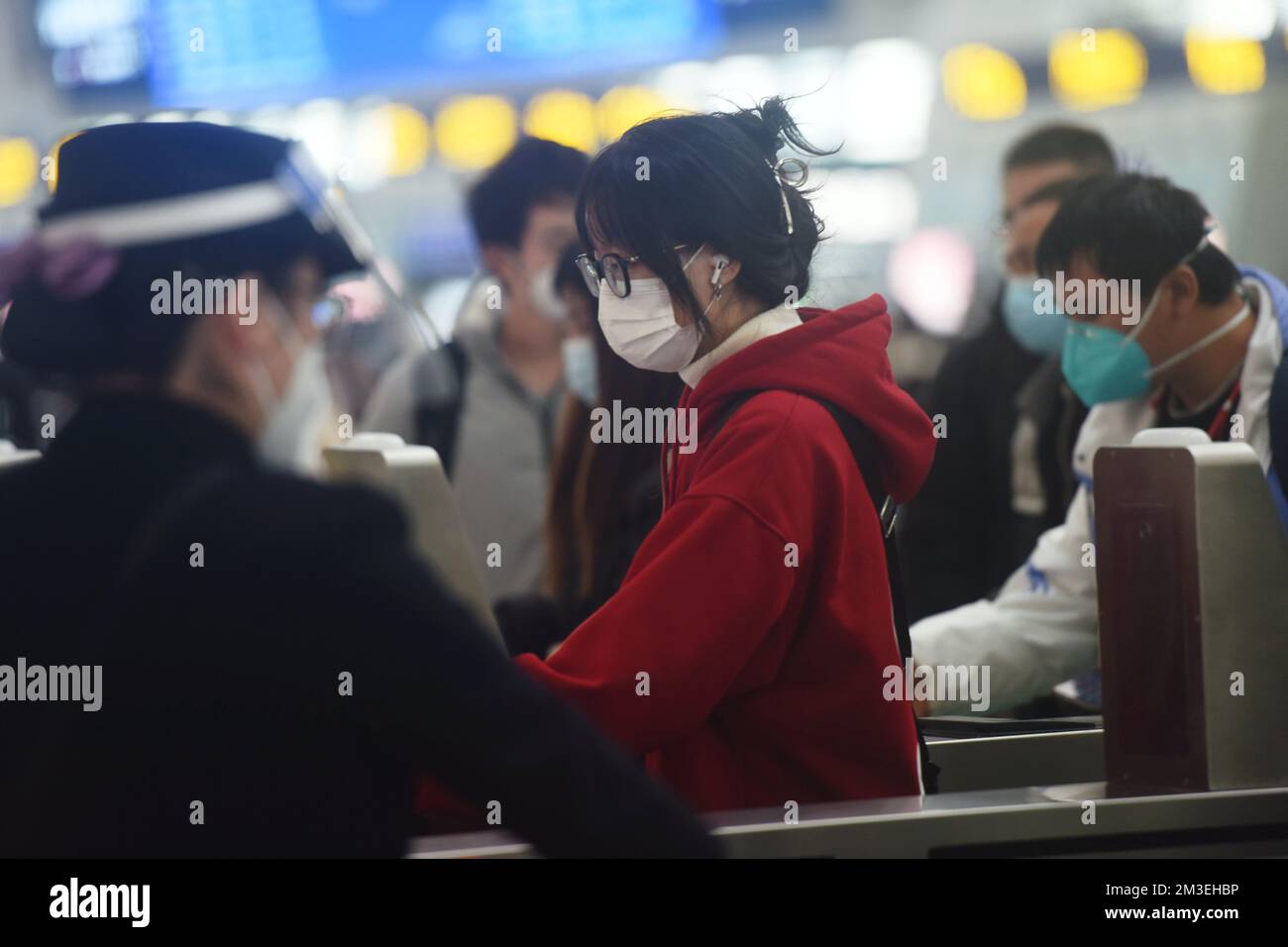 HANGZHOU, CINA - 15 DICEMBRE 2022 - Un gran numero di passeggeri che indossano maschere passa attraverso la barriera automatica dei biglietti presso la sala d'attesa di Hang Foto Stock