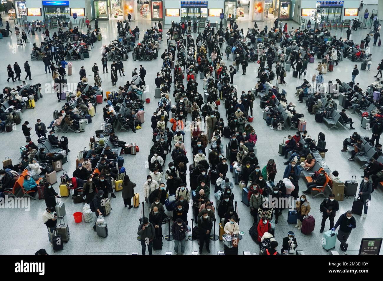 HANGZHOU, CINA - 15 DICEMBRE 2022 - Un gran numero di passeggeri che indossano maschere aspettano nella sala d'attesa della stazione ferroviaria di Hangzhou Est Foto Stock