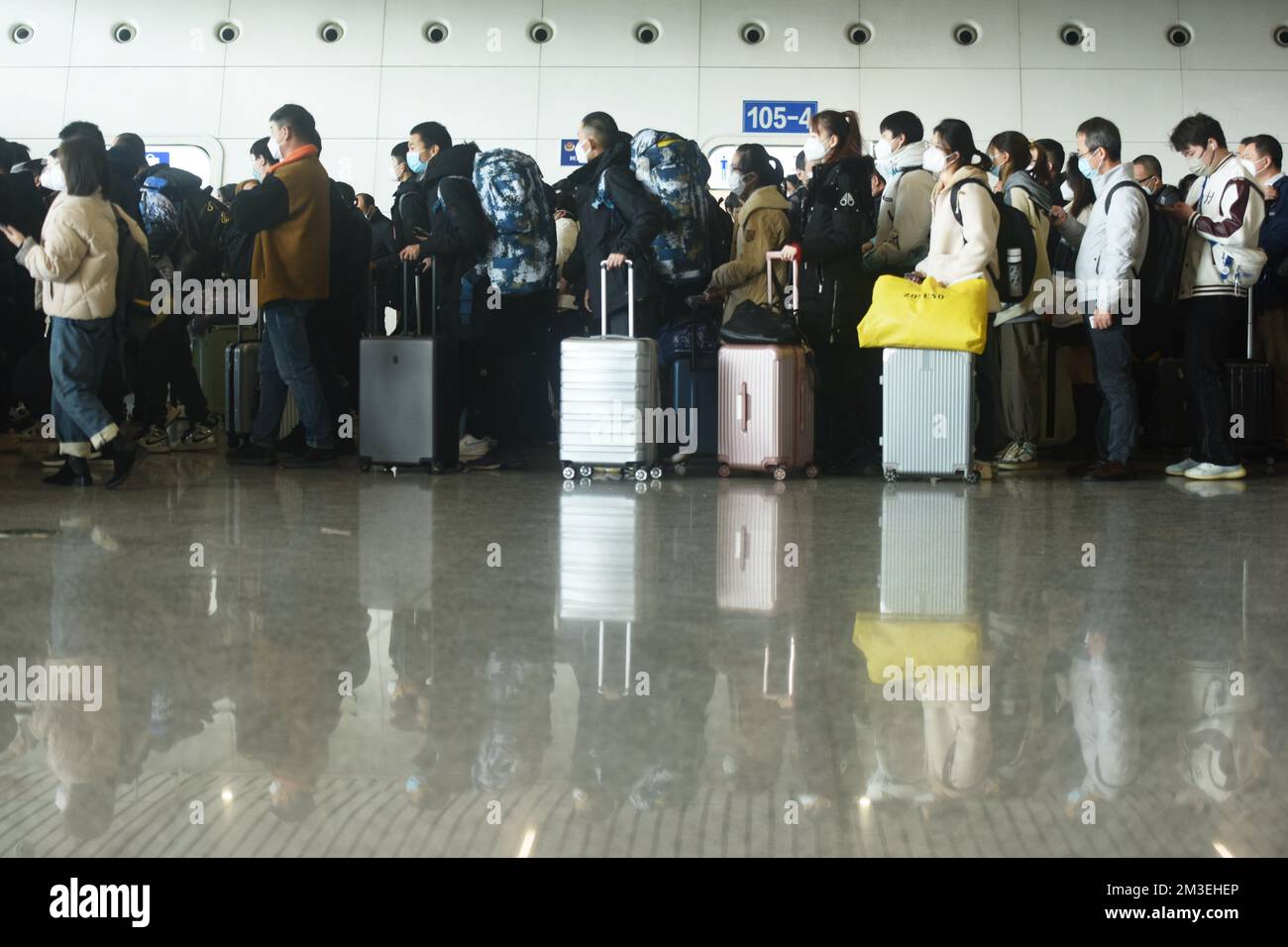 HANGZHOU, CINA - 15 DICEMBRE 2022 - Un gran numero di passeggeri che indossano maschere aspettano nella sala d'attesa della stazione ferroviaria di Hangzhou Est Foto Stock
