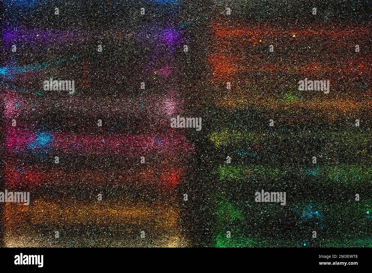 tracce di colori astratti su una superficie nera Foto Stock