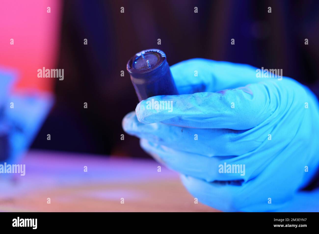 condensatore elettrico dall'alimentazione del calcolatore in mano su sfondo colorato Foto Stock