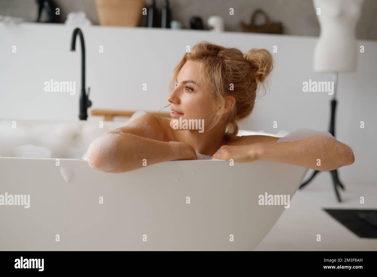 Ritratto di giovane donna penitente che prende il bagno e guarda via Foto Stock