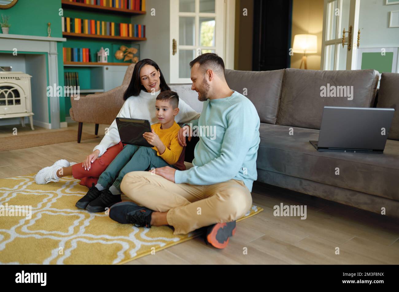 Famiglia felice che utilizza un tablet mobile a casa insieme Foto Stock