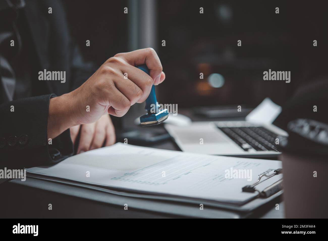 Appendi la mano stampando il documento aziendale fattura finanziaria sulla scrivania. Foto Stock