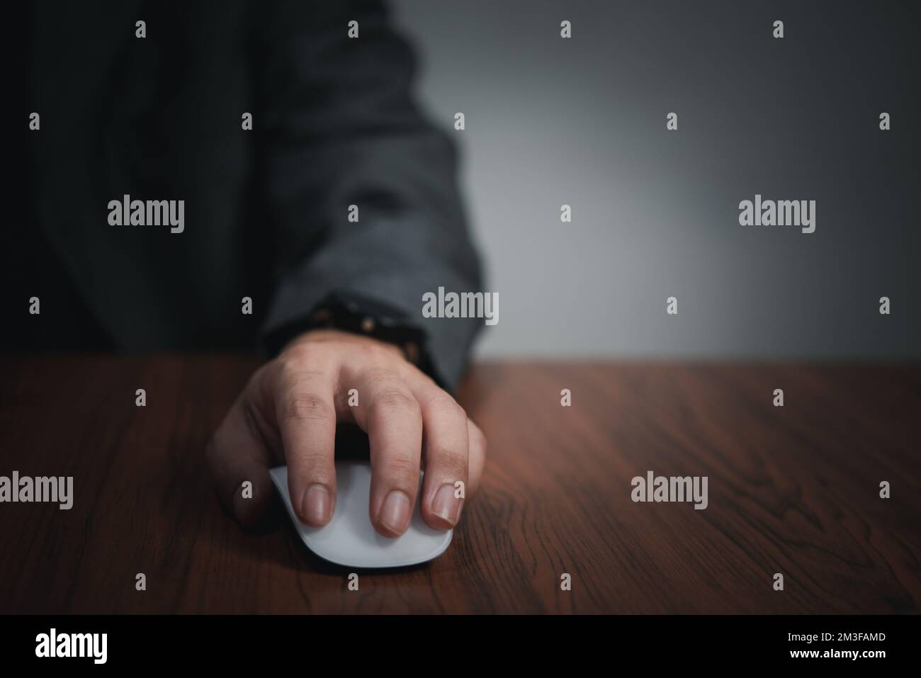 Mano con il mouse del computer, facendo clic sul puntatore del computer portatile sulla scrivania. Foto Stock