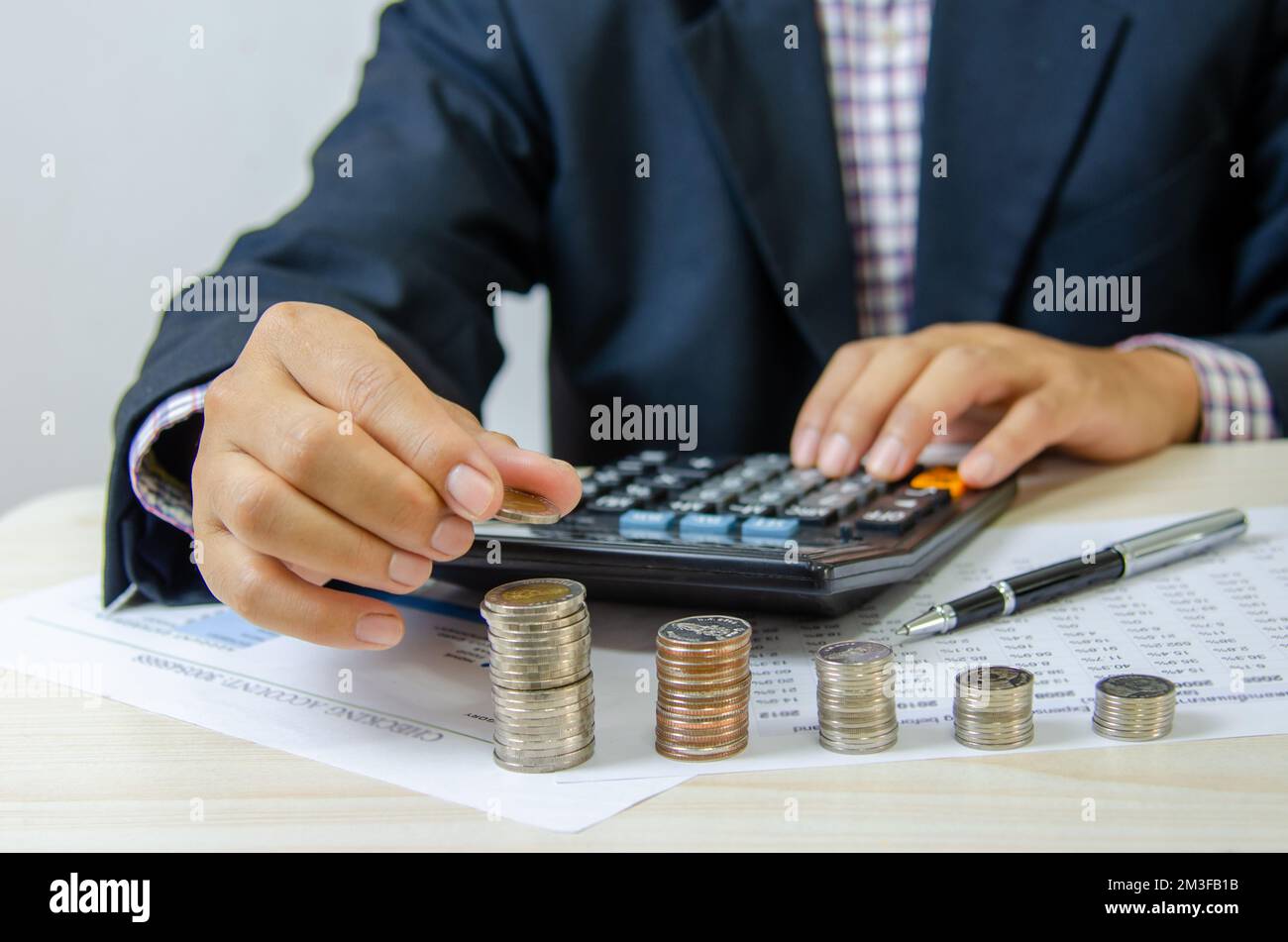 Businessman che tiene la pila della moneta sulla scrivania.Business investimento finanza soldi di risparmio bancario e gestione contabile di marketing concetto. Foto Stock