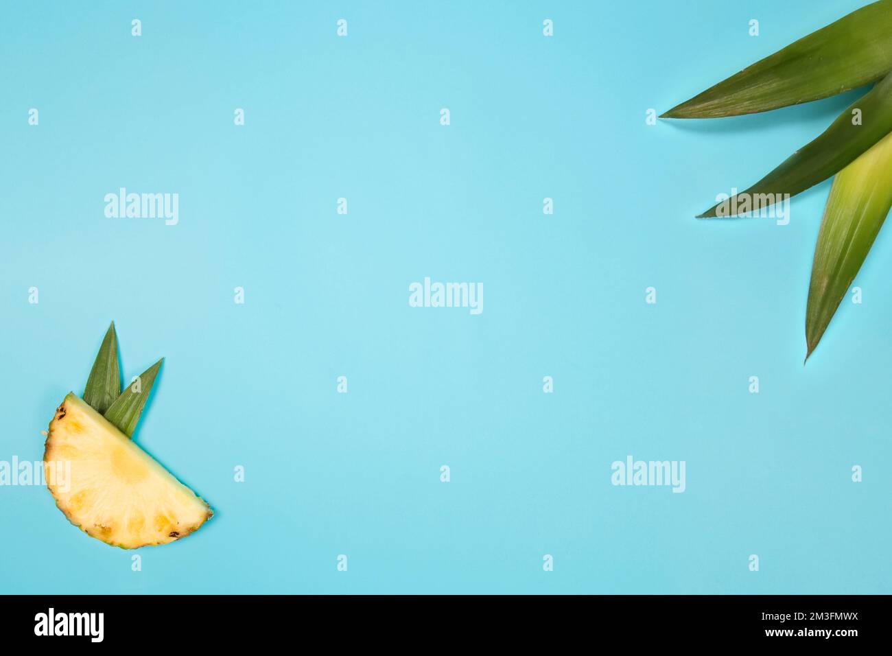 fette di ananas che formano un cuore sul terreno su uno sfondo blu Foto Stock