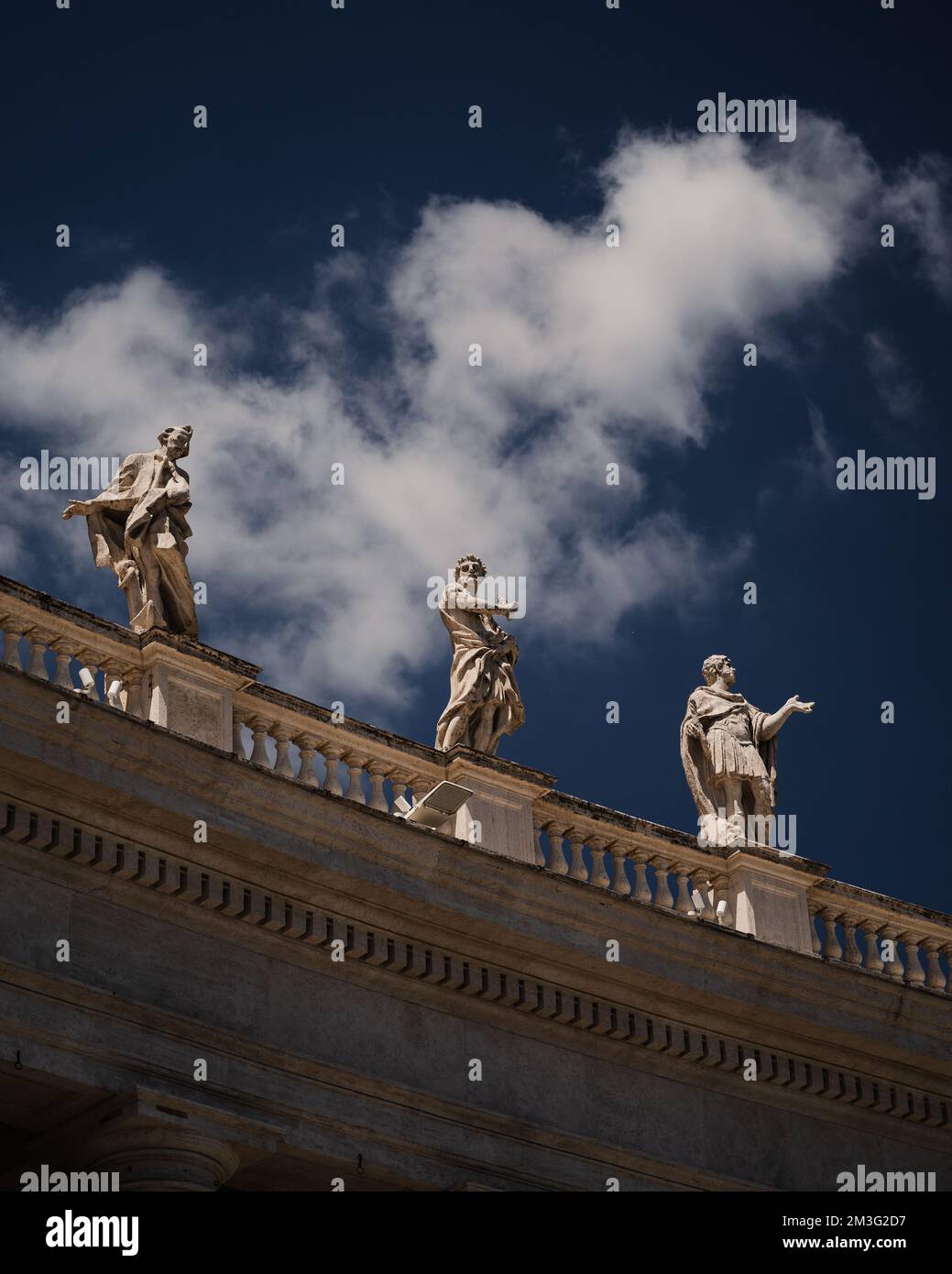 Le statue dei Santi e dei Martiri in Piazza San Pietro sotto il cielo nuvoloso e azzurro della Città del Vaticano Foto Stock