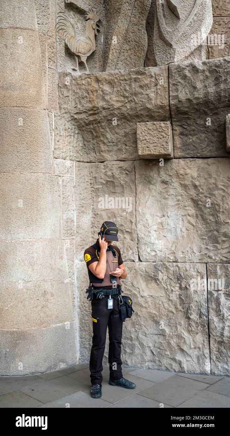 Ufficiale di polizia in uniforme che parla sul suo cellulare di servizio, Barcellona, Catalogna, Spagna Foto Stock
