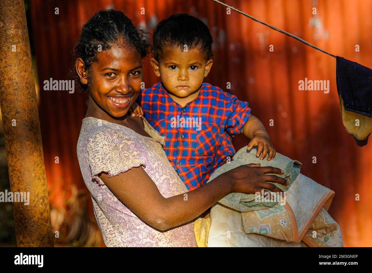 Ragazza amichevole che tiene un bambino in braccio, Berenty riserva privata, Madagascar meridionale Foto Stock