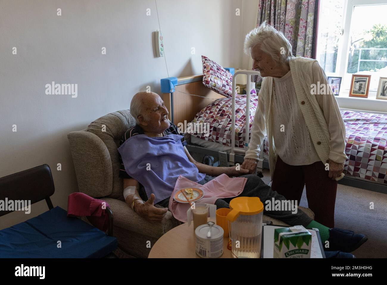 Coppia anziana negli anni 80 insieme nella loro camera da letto in una casa di cura nel sud-ovest dell'Inghilterra, Regno Unito Foto Stock