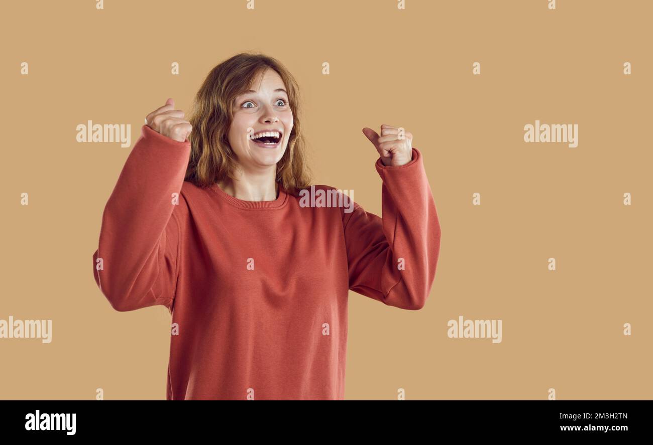 Ritratto di felice eccitato sorpresi giovane donna stupita sorridente e celebrando il successo Foto Stock