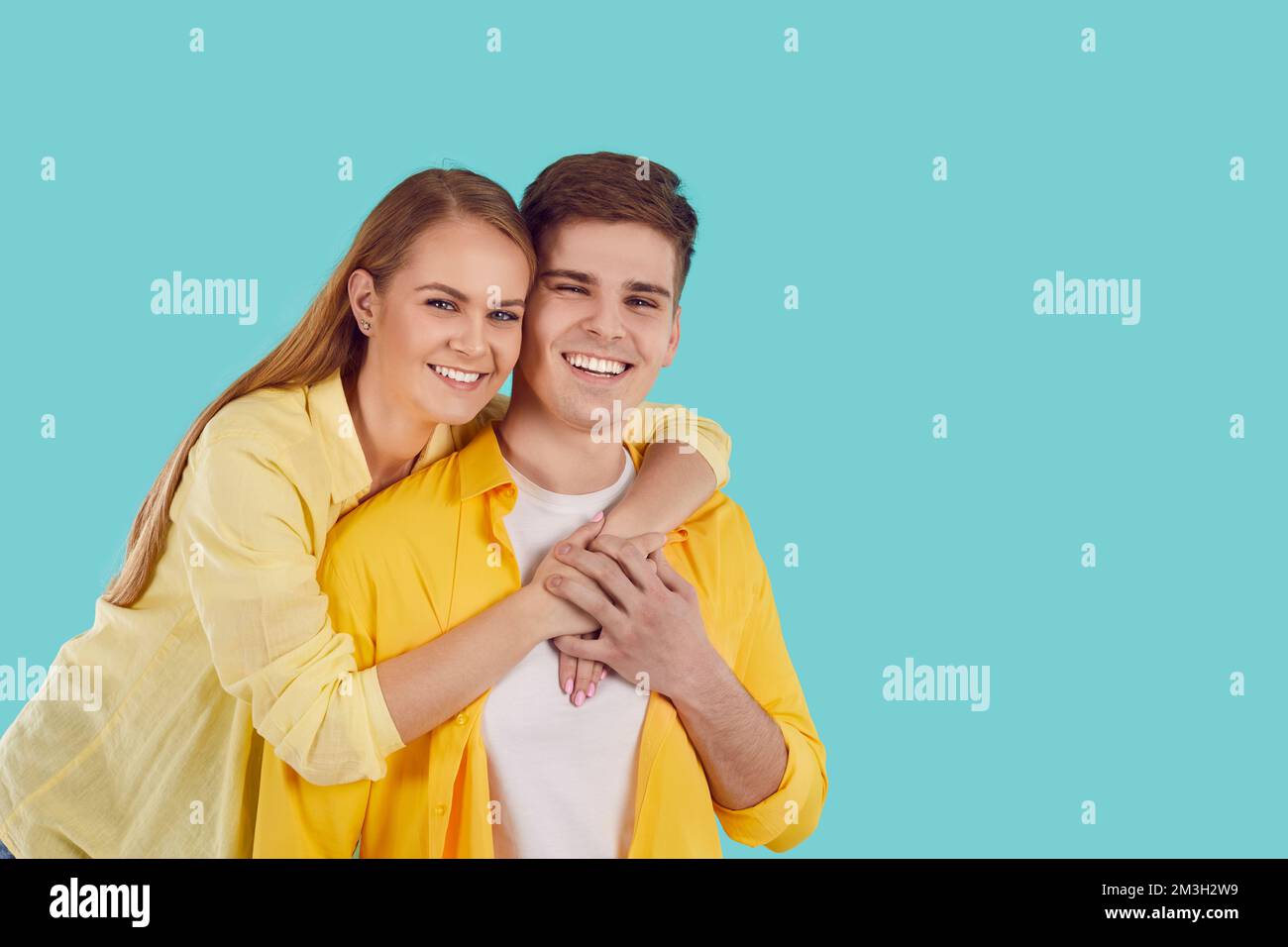 Abbraccio sorridente di coppia in posa insieme Foto Stock