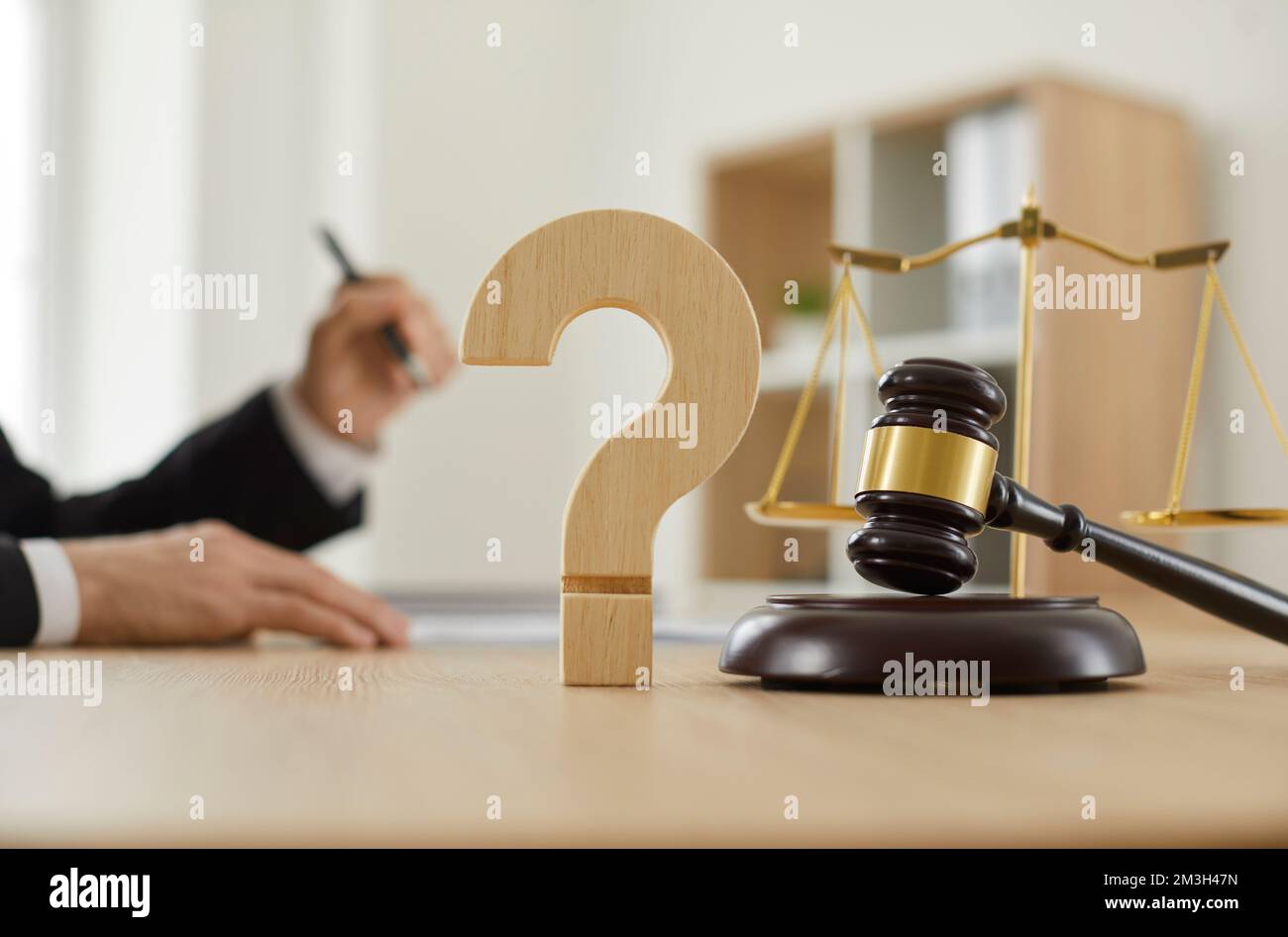 Primo piano di un punto interrogativo e di un gavel sul tavolo in aula o ufficio dell'avvocato Foto Stock