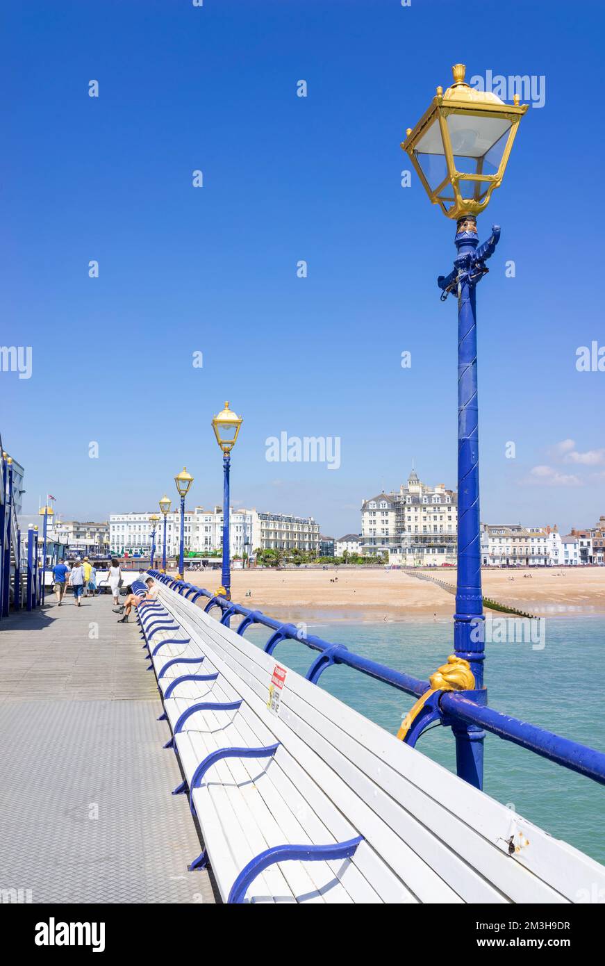 Eastbourne East Sussex guardando indietro lungo il molo verso le persone seduti su panchine laterali su Eastbourne Pier Eastbourne East Sussex Inghilterra UK GB Europe Foto Stock