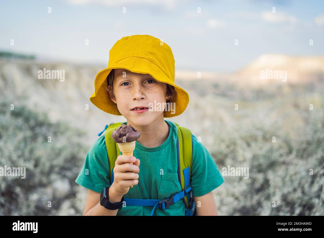 Ragazzo turistico che mangia gelato turco mentre esplori la valle con formazioni rocciose e grotte delle fate vicino a Goreme in Cappadocia Turchia Foto Stock