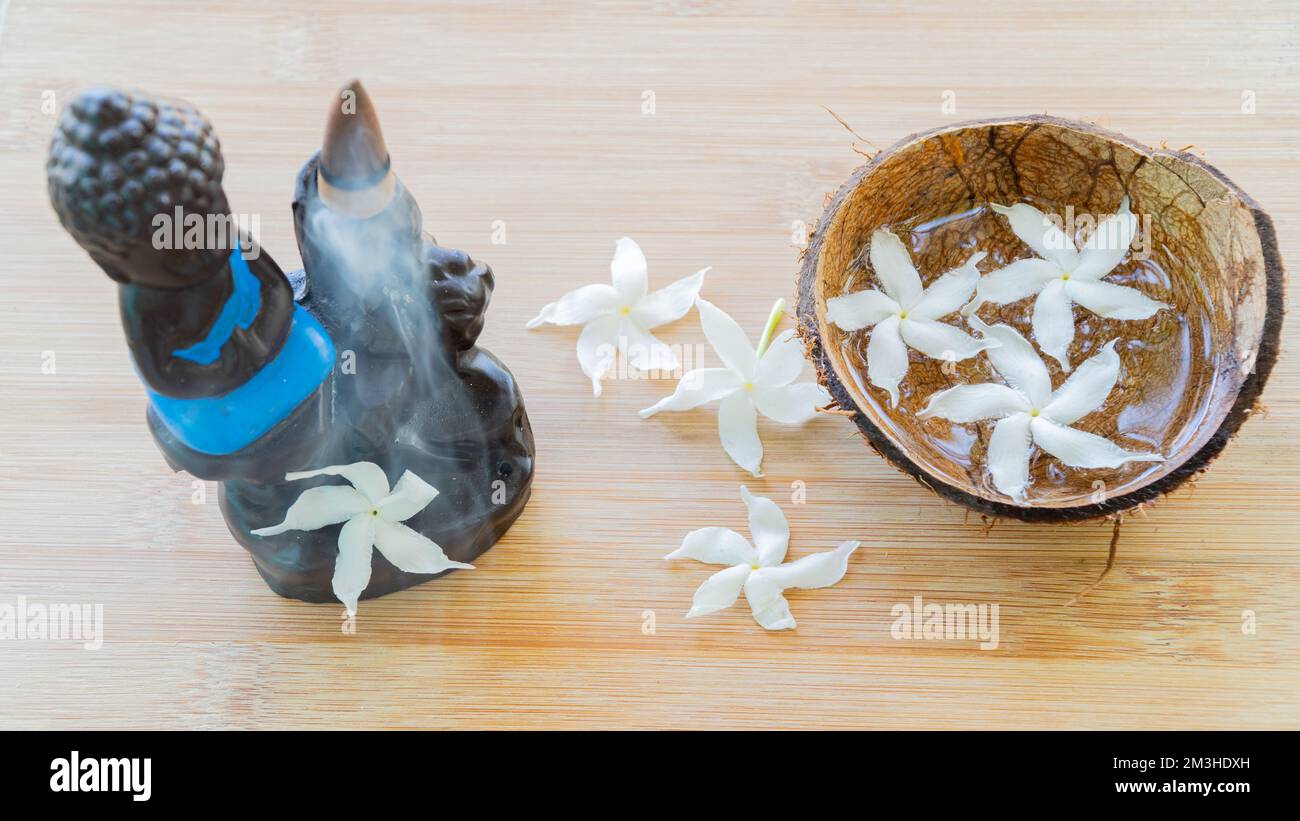 Buddha figurina per incenso con fiori, meditazione Foto Stock