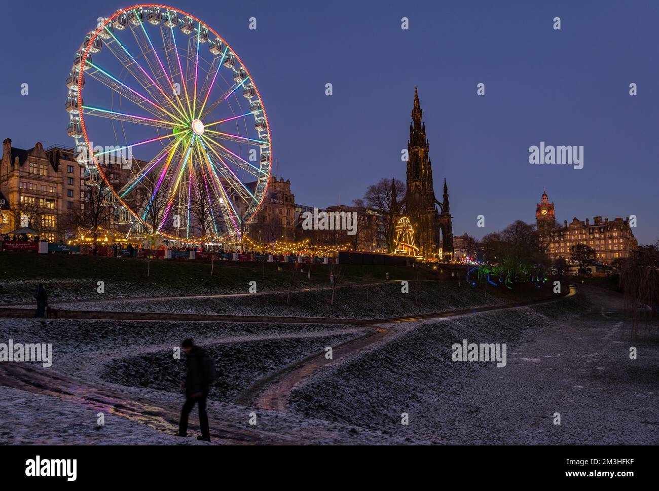 Edimburgo, Scozia, Regno Unito, 15th dicembre 2022. Natale: Il mercatino di Natale e la Grande ruota sono illuminati al crepuscolo con la neve a terra nei Princes Street Gardens. Credit: Sally Anderson/Alamy Live News Foto Stock