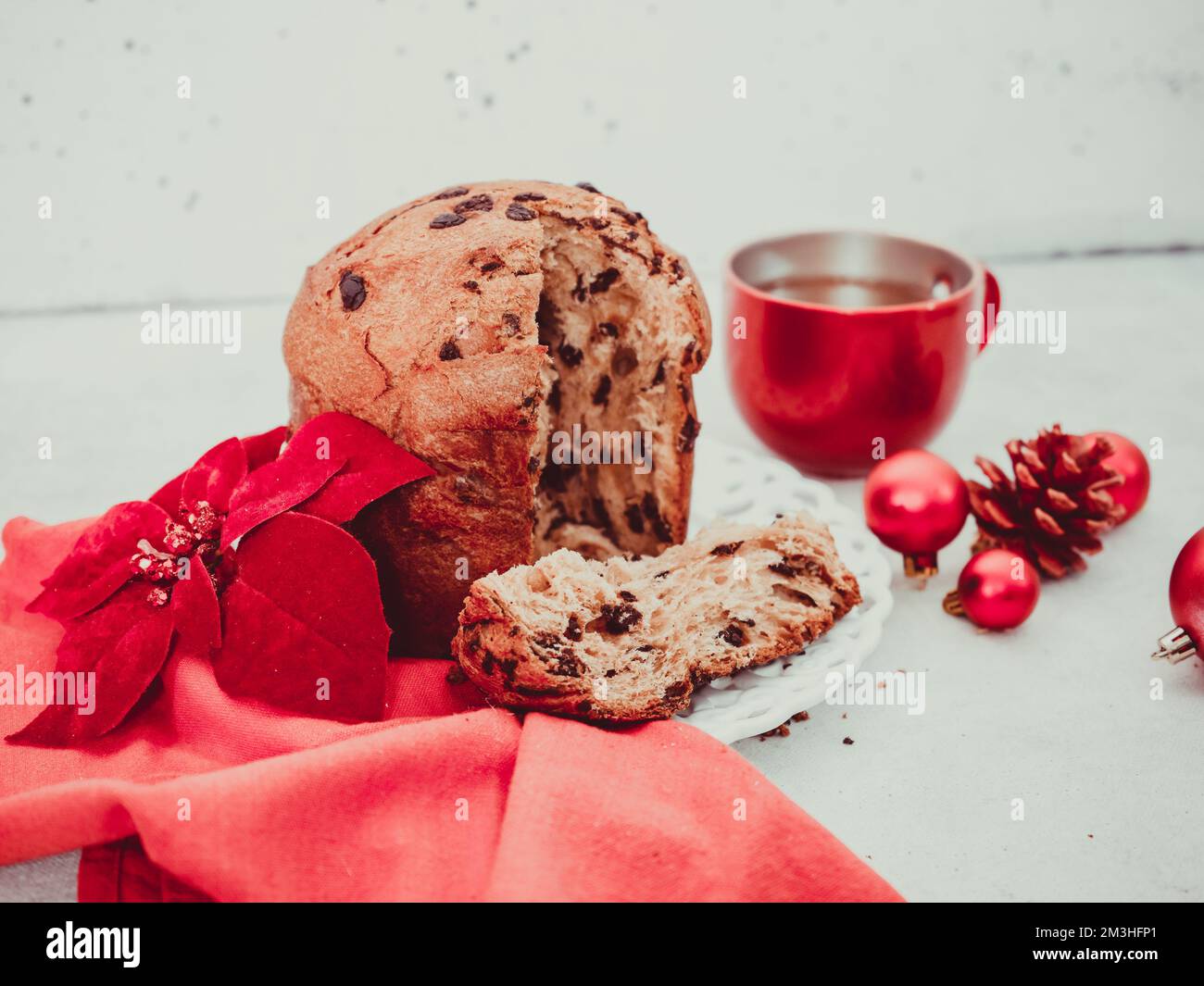 paneton con tè e una candela all'estrema destra su uno sfondo di cemento nero. Foto Stock