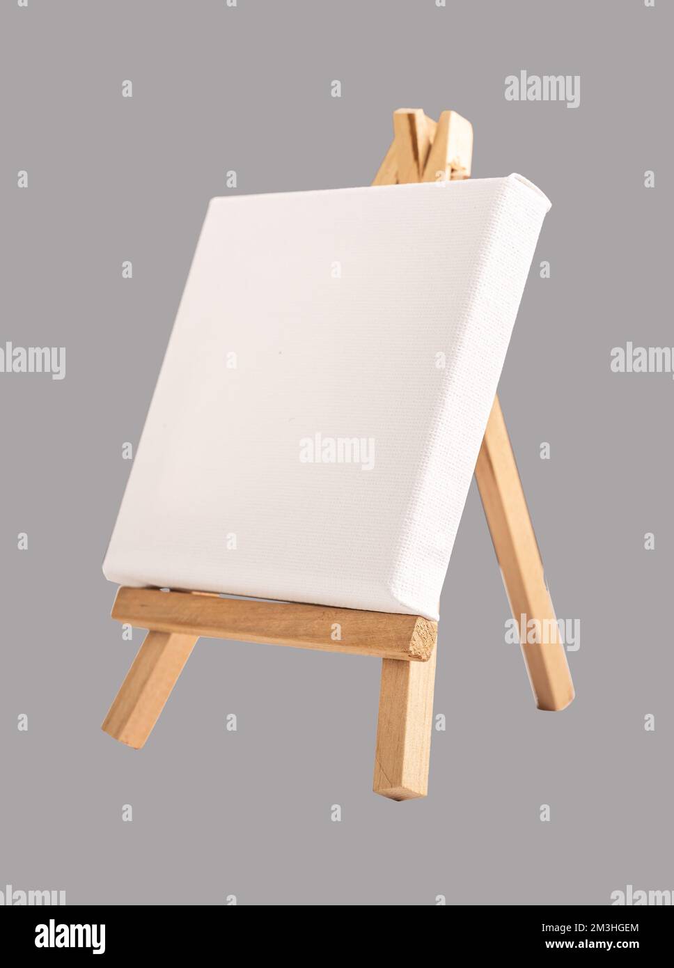 Bianco vuoto canvas mock up su mini cavalletto di legno su sfondo grigio. Foto di alta qualità Foto Stock
