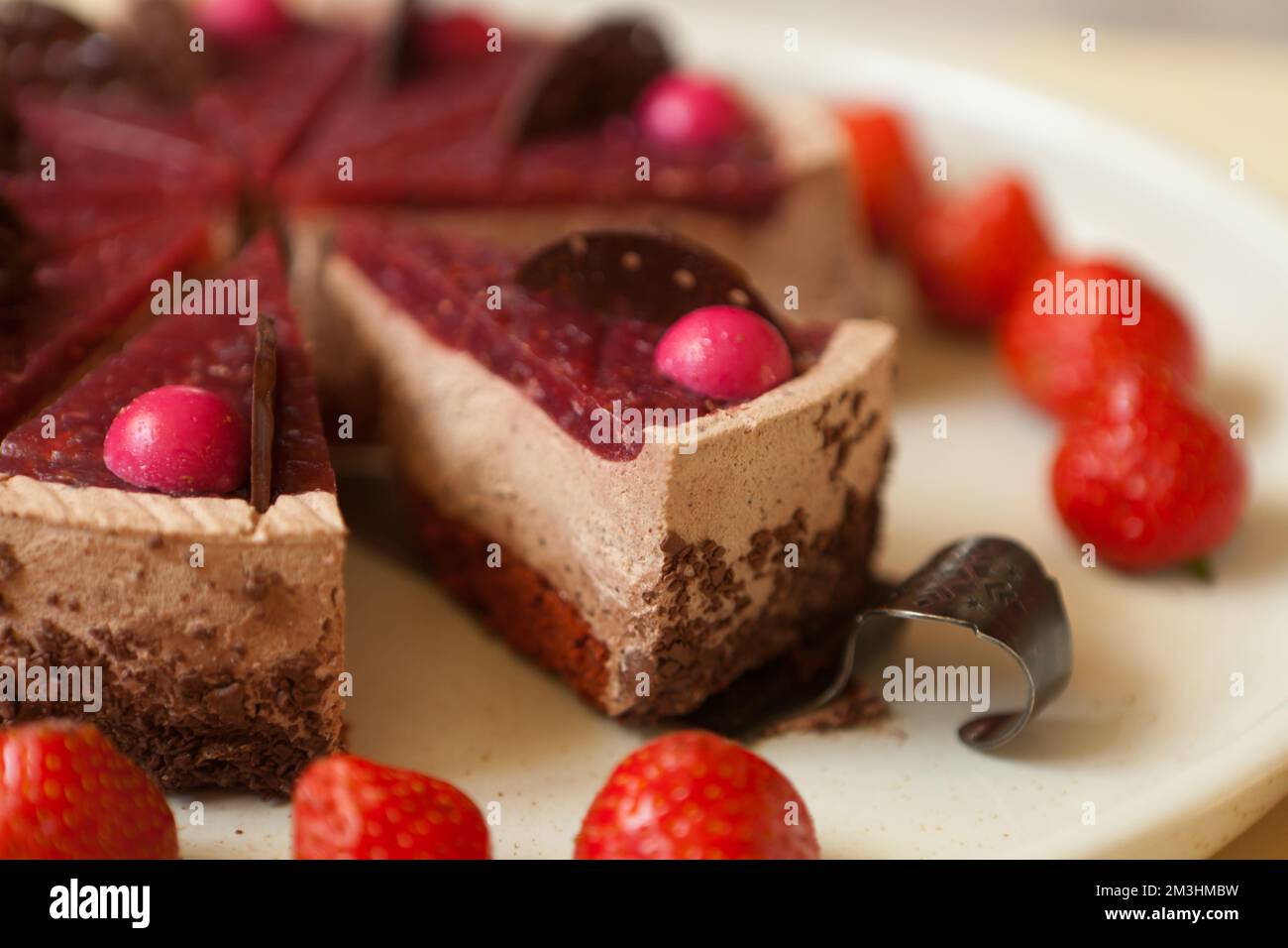 torta al cioccolato con fragole primo piano. affettare con gocce di cioccolato e souffle. Pasticceria Foto Stock