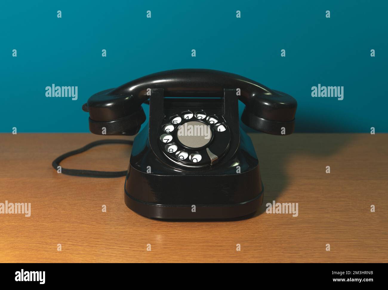 vecchio telefono su un tavolo di legno, sfondo blu. spazio di copia Foto Stock