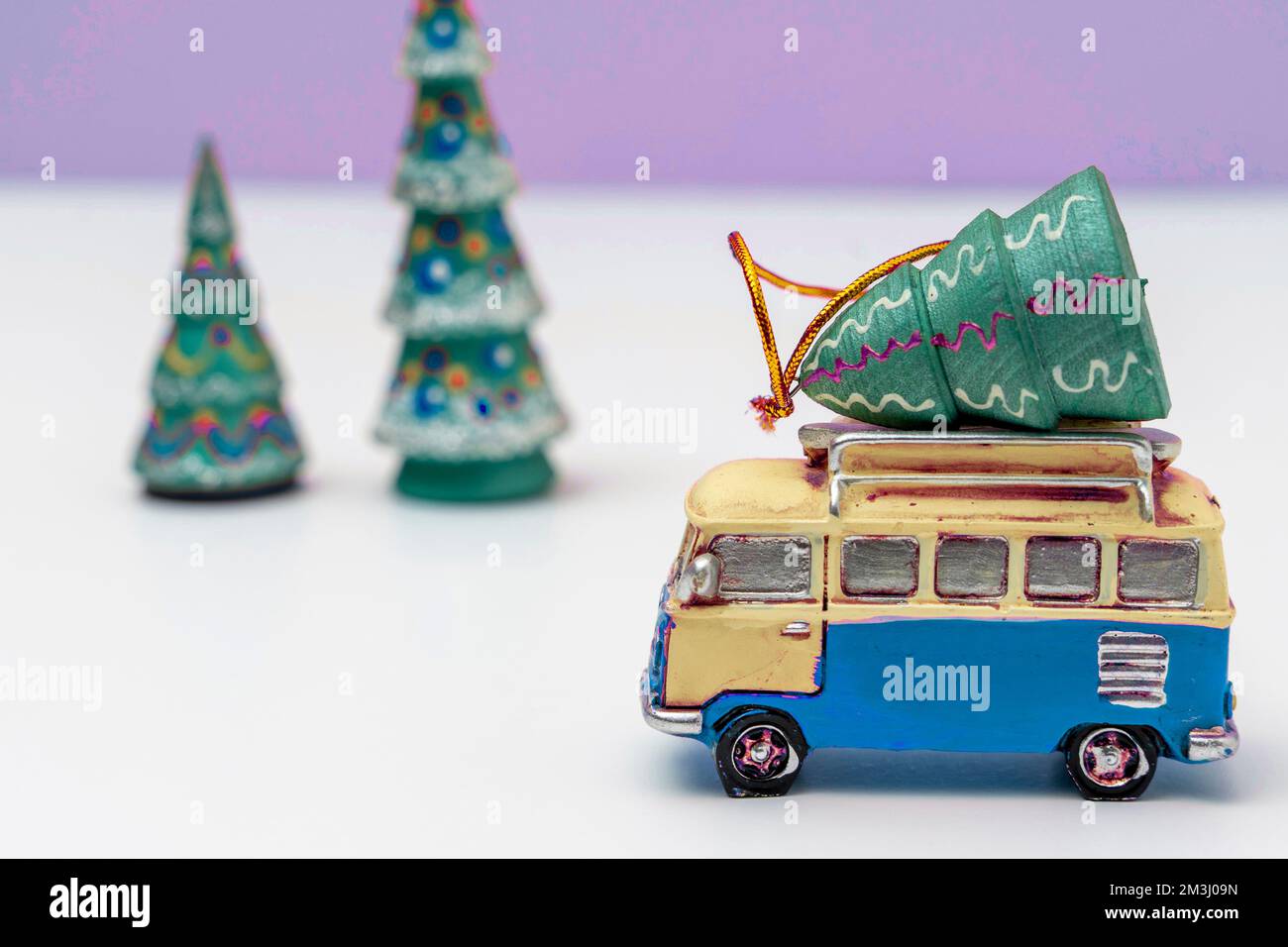 L'automobile del giocattolo sta trasportando un albero di Natale del giocattolo. Albero di Natale e minibus Foto Stock