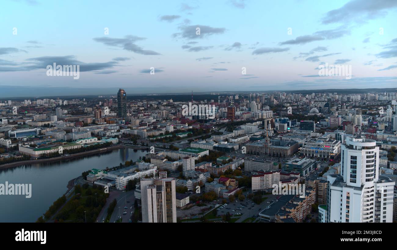 Vista aerea di un moderno grattacielo di uffici in vetro con riflessi della città nelle finestre. Riprese in stock. Volare sopra la città moderna su un Foto Stock