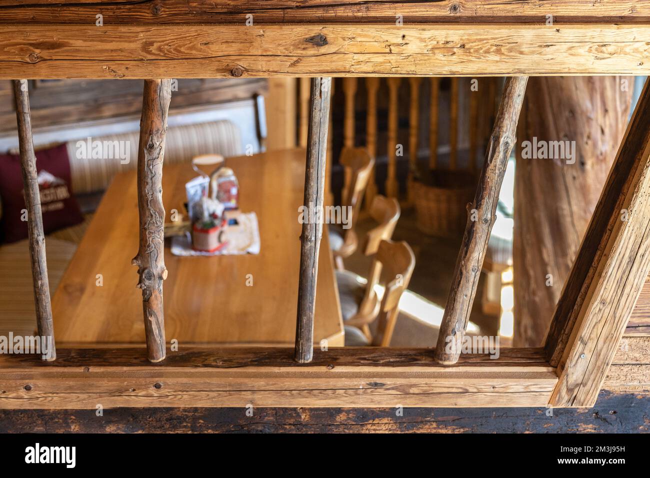 Vista su un angolo accogliente con tavolo e sedie attraverso un reticolo di legno in un ristorante alpino, Austria, Salisburgo Foto Stock