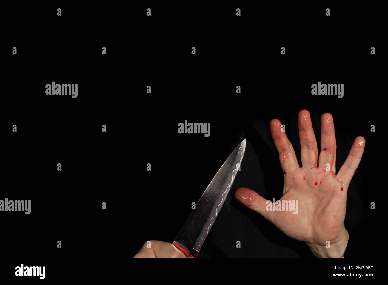 Coltello per tenere la mano colorato con sangue falso, su sfondo nero.  Concetto di attacco dei coltelli Foto stock - Alamy