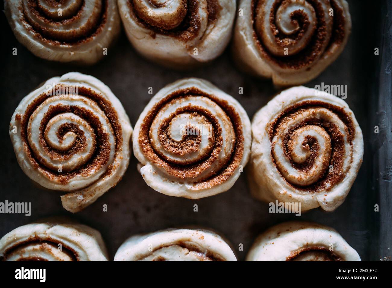 Primo piano di tre dolci alla cannella non cotti Foto Stock