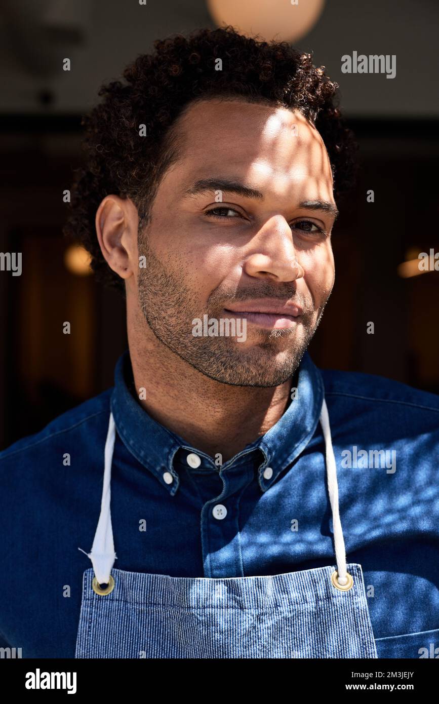 Ritratto del proprietario di caffè maschile con luce solare sul viso Foto Stock