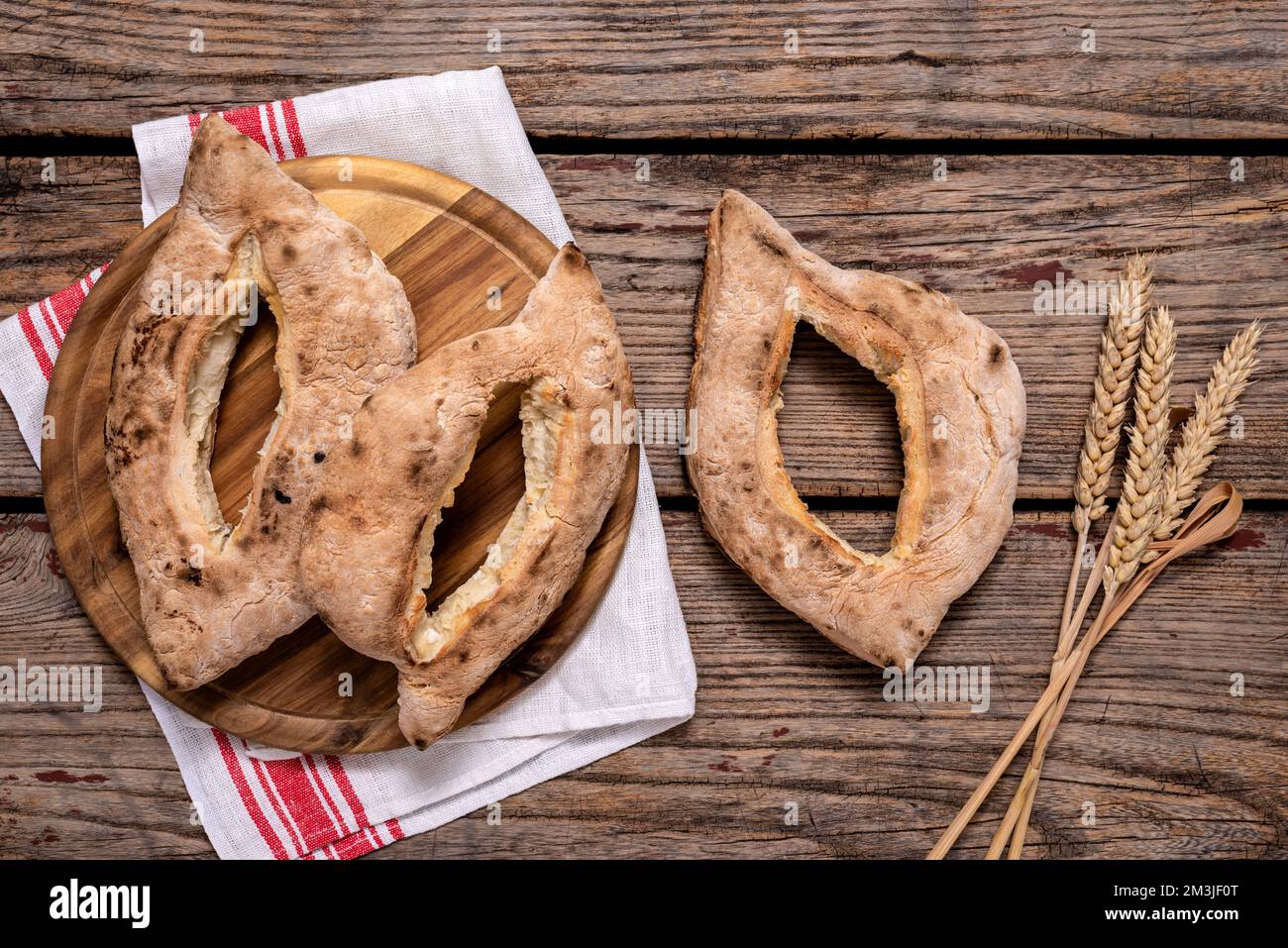 I tradizionali panini cotti in casa serbi (lepinja) e le spighe di grano maturo su tavola di legno. Foto Stock