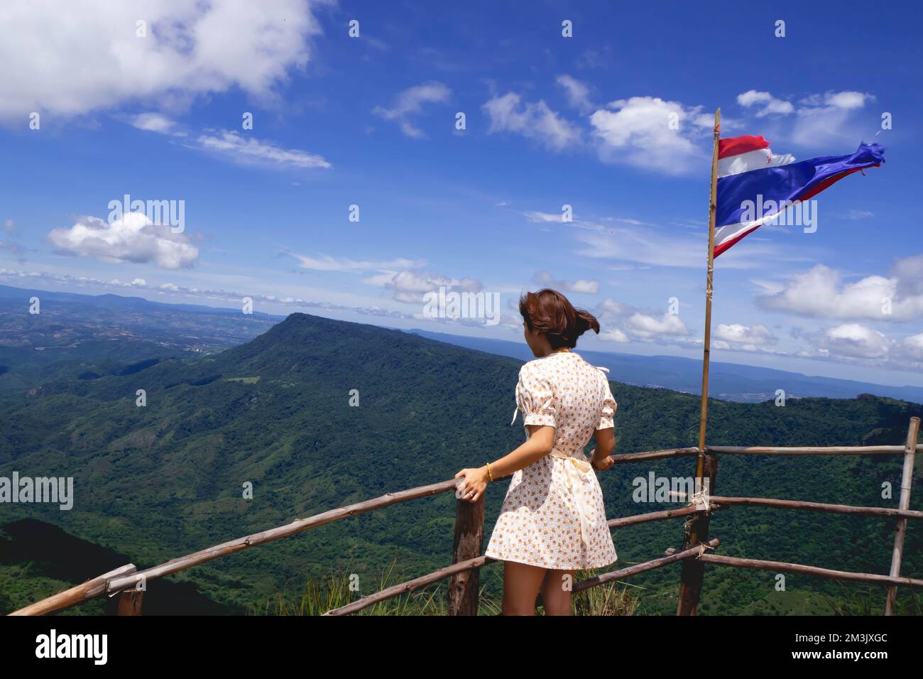 Donna in gonna e bandiera nazionale tra la natura Foto Stock