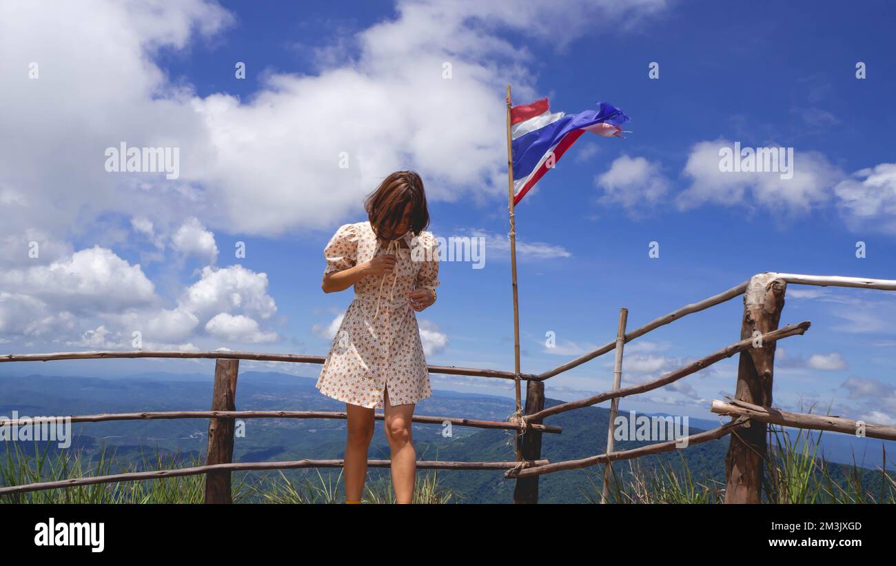 Donna in gonna e bandiera nazionale tra la natura Foto Stock