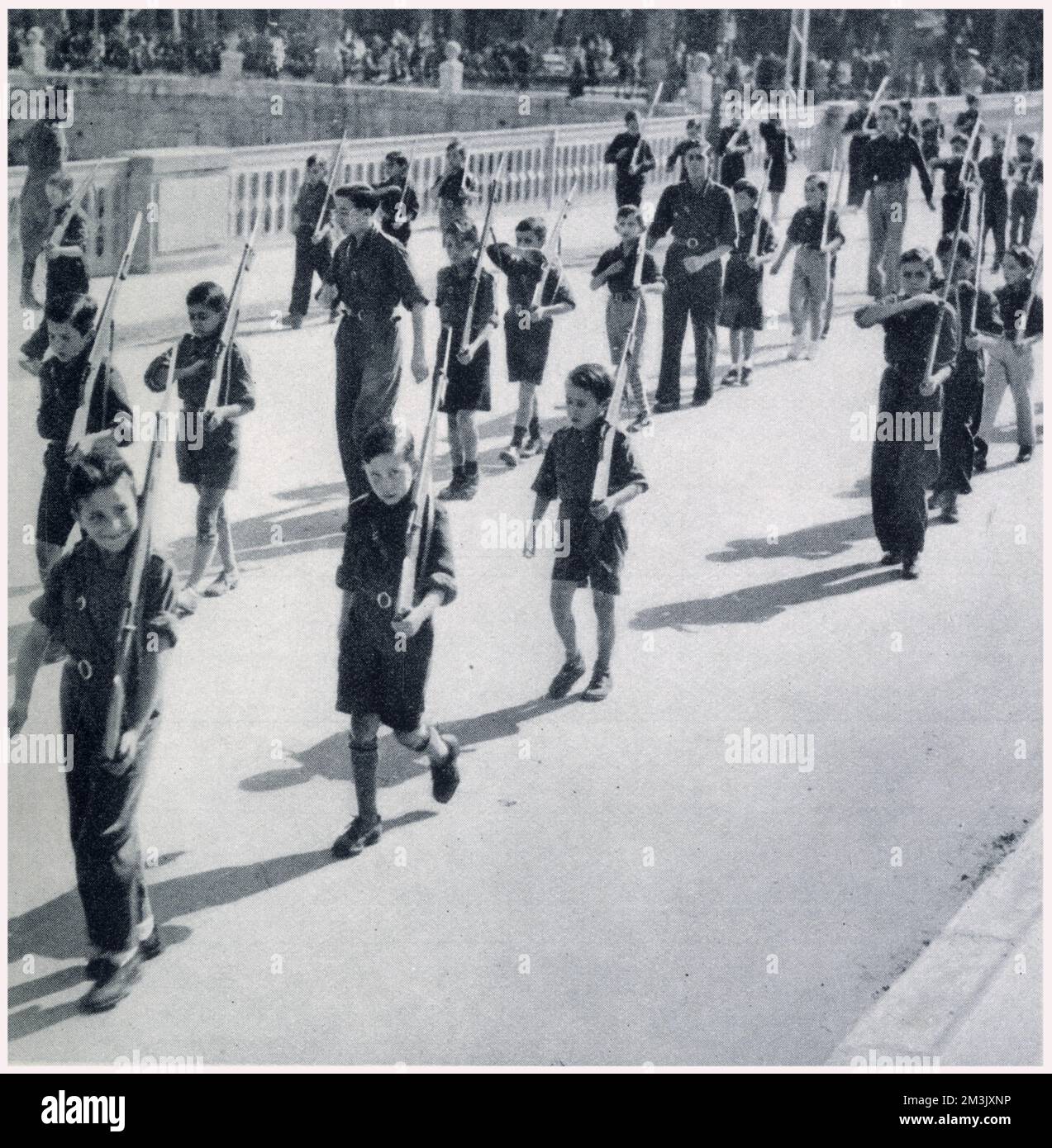 Figli spagnoli delle frecce del generale Franco (giovani fascisti), marciando con fucili fittizi, Burgos. Foto Stock