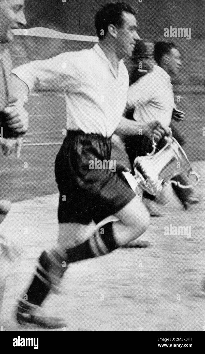 Capitano Everton e centro-avanti, Dixie Dean (1907 - 1980), correndo intorno Wembley Stadium dopo il F.A. Finale della Coppa del 1933. Dean, che ha segnato l'unico gol nella partita tra Everton e Manchester City, tiene la victor's Cup nella sua mano sinistra. Data: 1933 Foto Stock