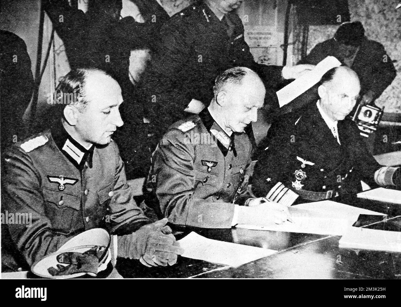 Fotografia che mostra il generale Gustav Jodl (centro), il capo di stato maggiore nazista, firmando la resa incondizionata della Germania, ponendo fine alla seconda guerra mondiale in Europa. Questa consegna si è svolta presso la Suprema sede della forza d'espeditionio alleata a Reims in Francia il 7th maggio 1945. Data: 1945 Foto Stock