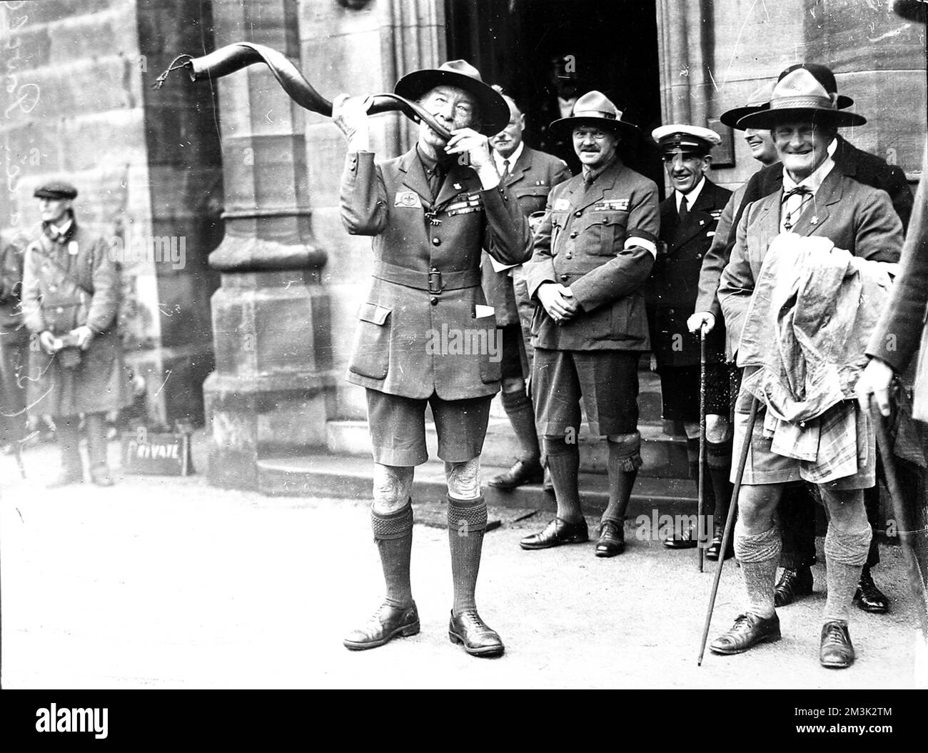 Sir Robert Baden-Powell (1857 - 1941) (al centro), soldato inglese e fondatore dei Boy Scouts, suonando il corno del Kudu presso un Scouts World Jamboree, Birkenhead. Luglio 1929 Foto Stock