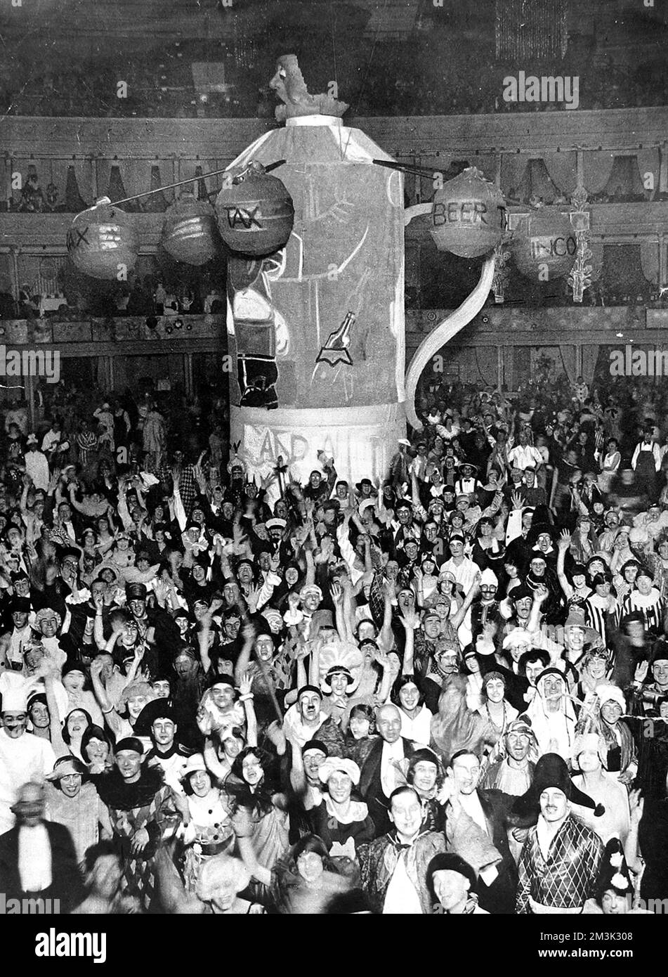 Revellers al Chelsea Arts Ball, la vigilia di Capodanno, 1923. Una monumentale figura di 'John Bull' guarda giù sui partecipanti del partito nei loro costumi di abito fantasia. 1923 Foto Stock